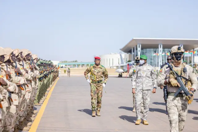 Le général Assimi Goïta, président de la transition au Mali, en tenue militaire passe en revue les troupes lors d'une cérémonie officielle.
