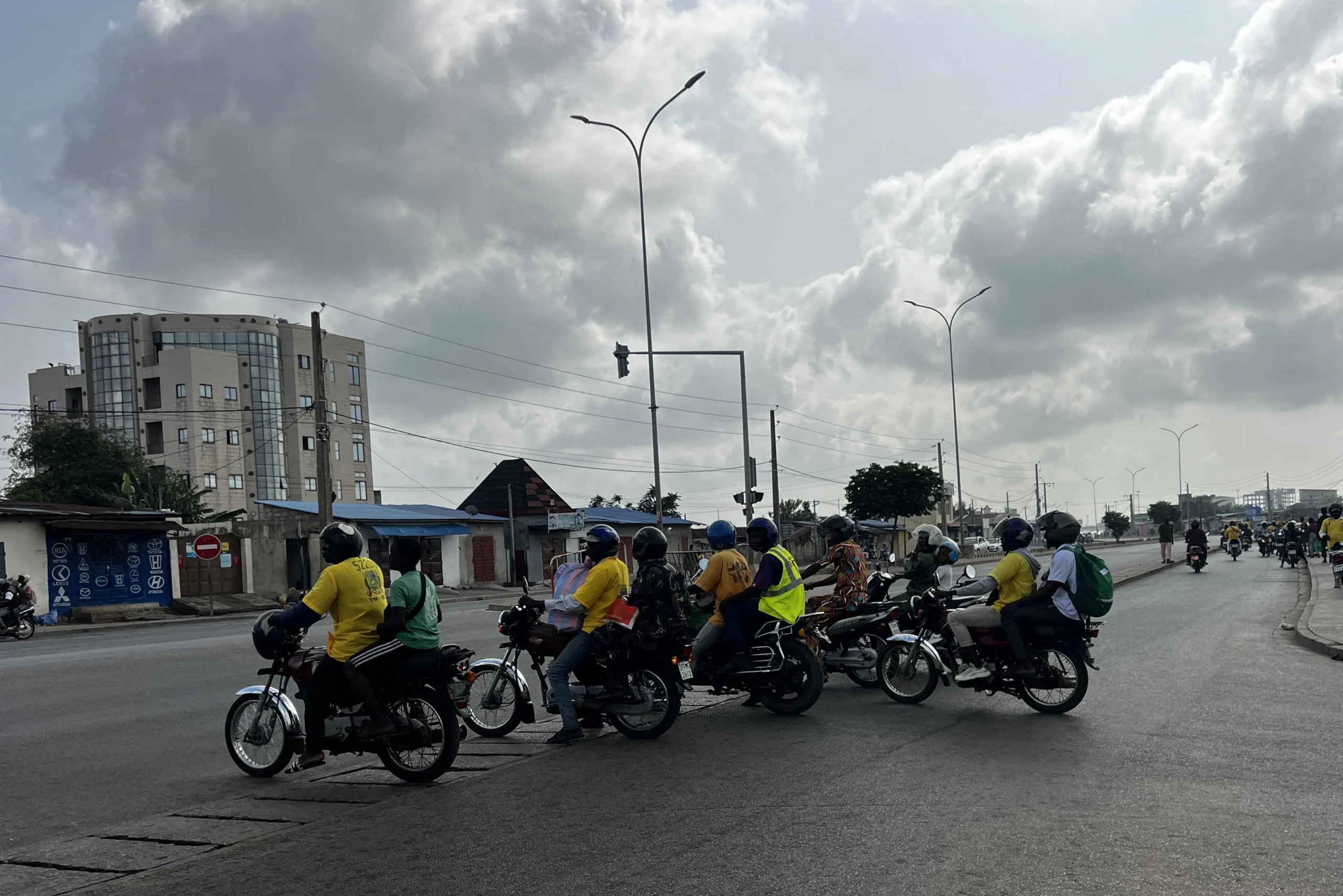 Motos-taxis et circulation animée dans une rue de Cotonou, alors que des rumeurs de coup d’État agitent la ville