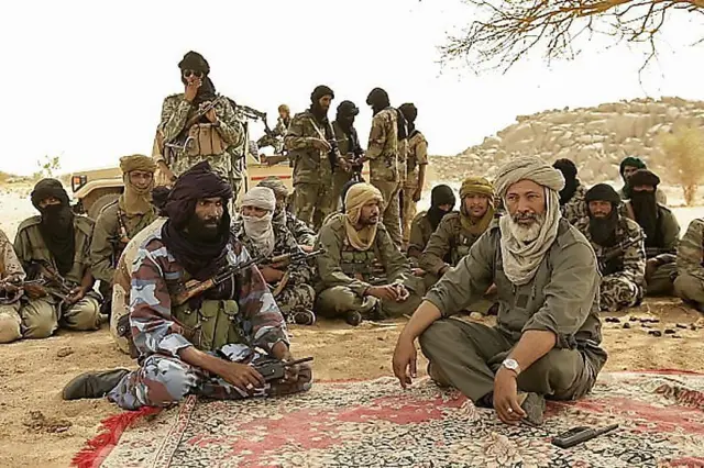 Combattants touaregs et arabes assis en cercle sous un arbre dans le nord du Mali.