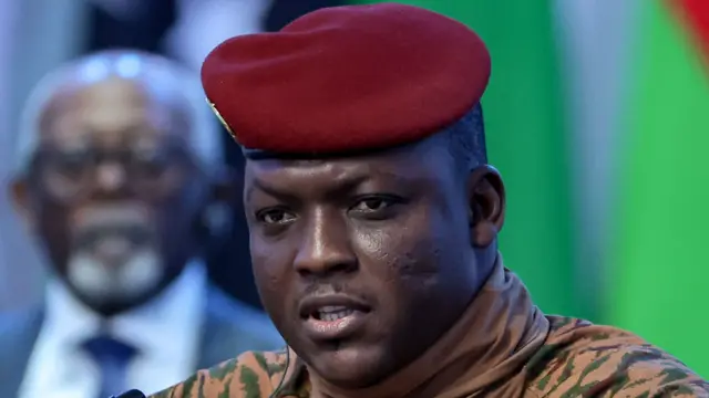 Portrait d'Ibrahim Traoré en tenue militaire beige avec un béret rouge