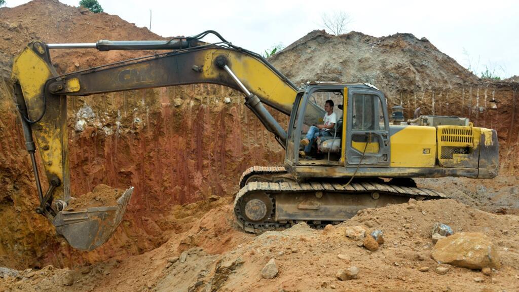 Un employé chinois d'une société minière conduit un bulldozer sur un site d'extraction d'or à Betare Oya, au Cameroun.