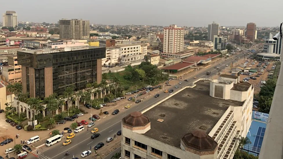 Un agent recenseur en discussion avec un habitant dans un quartier de Yaoundé
